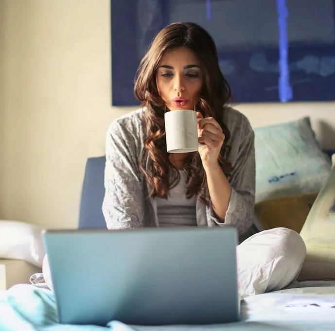 Femme utilisant un ordinateur sur son lit